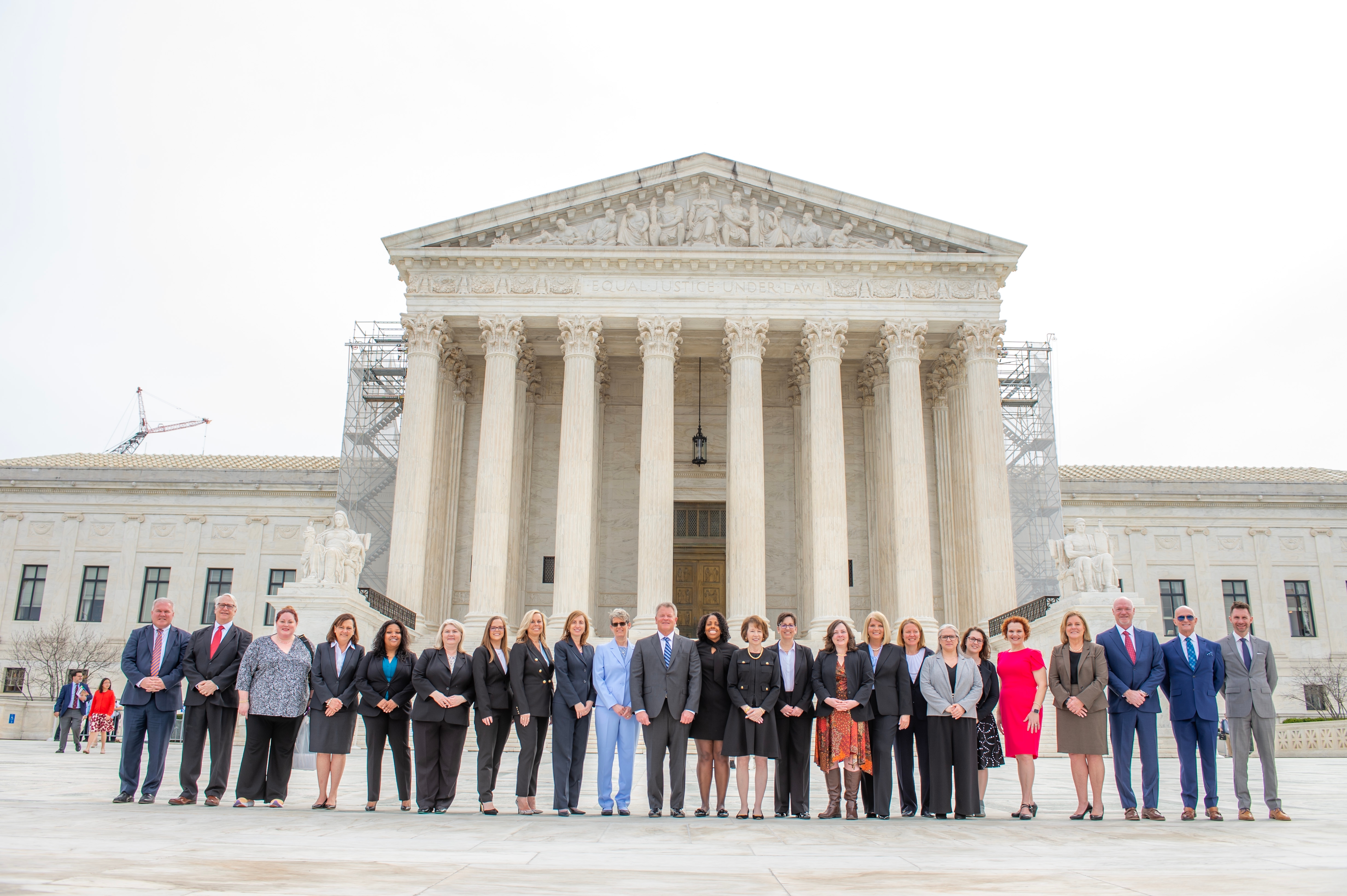 Large group of people gathered in front of the United States Supreme Court building.