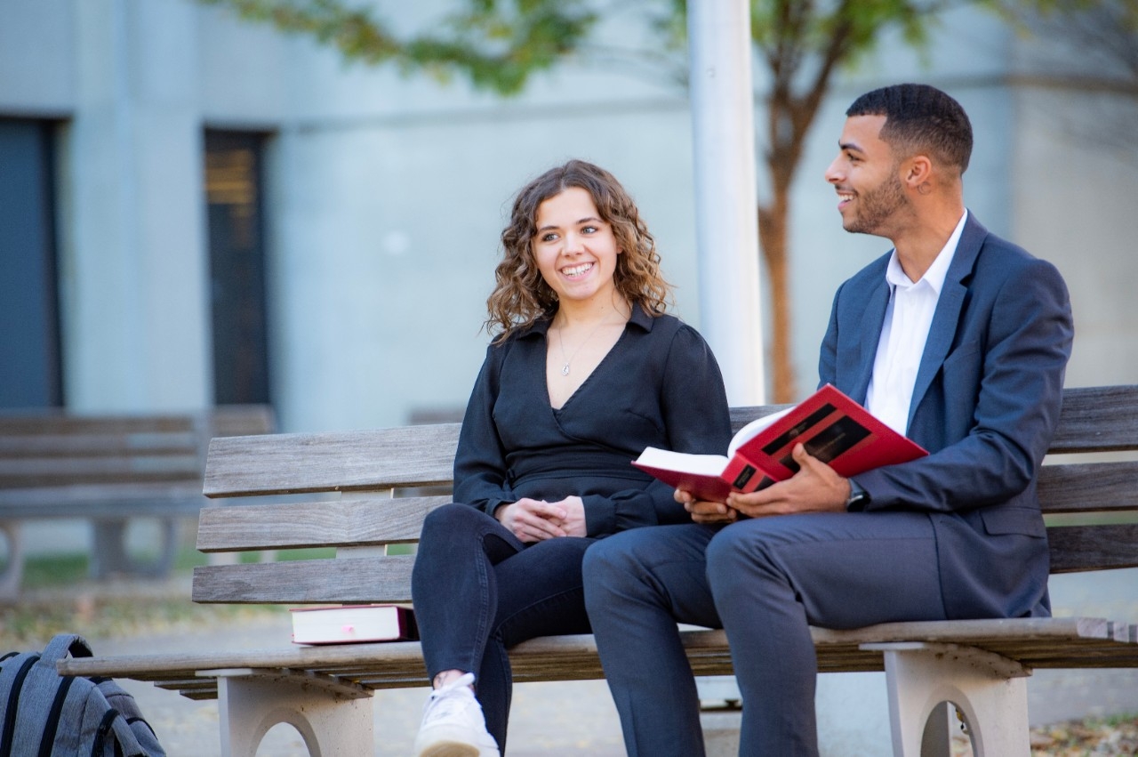 Two Chase Law students sitting on a bench togethter.