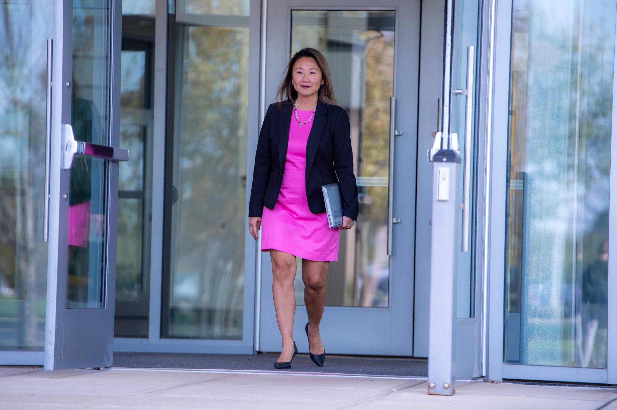 Professionally dressed woman walking out of a building