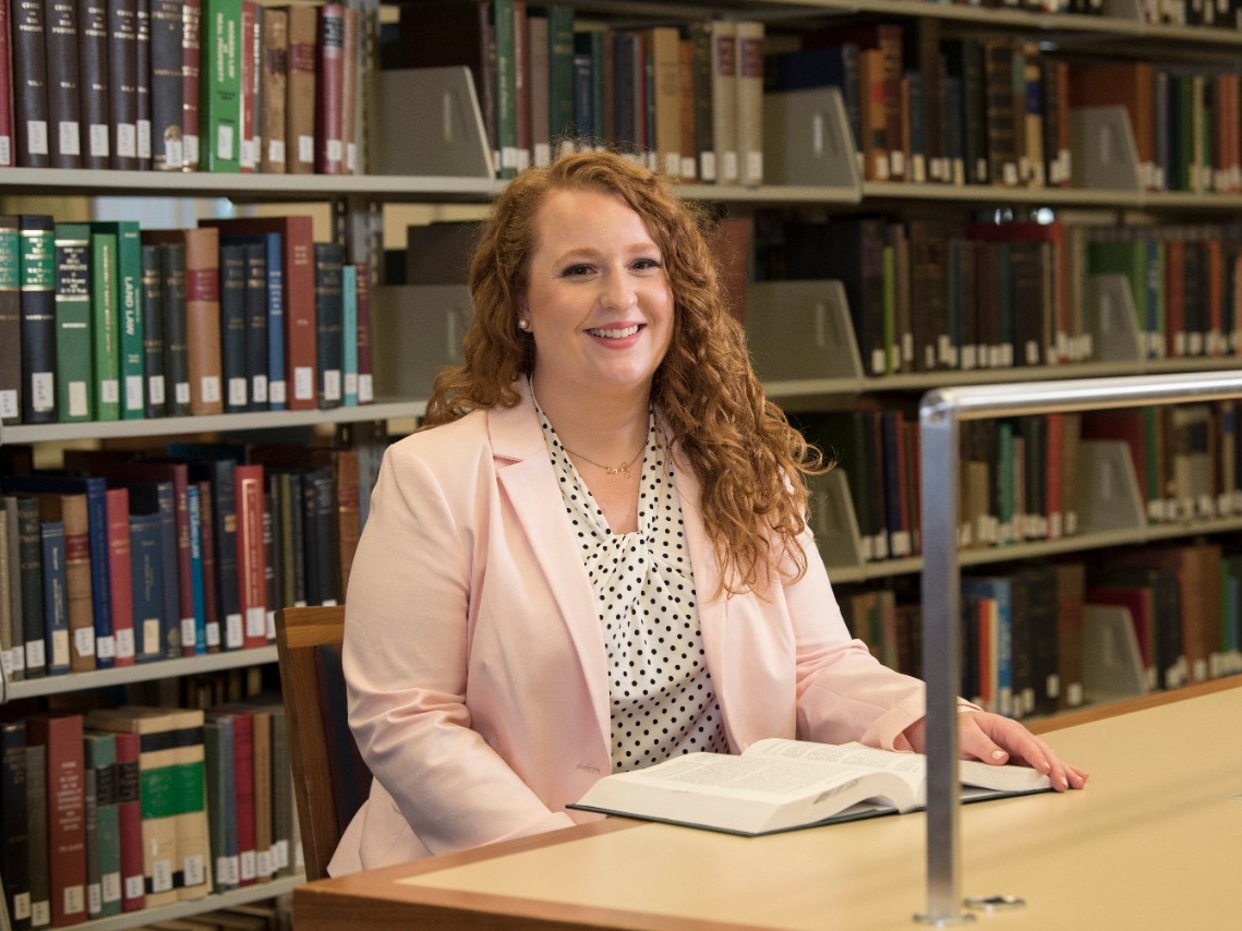 Professionally dressed woman sitting in a library