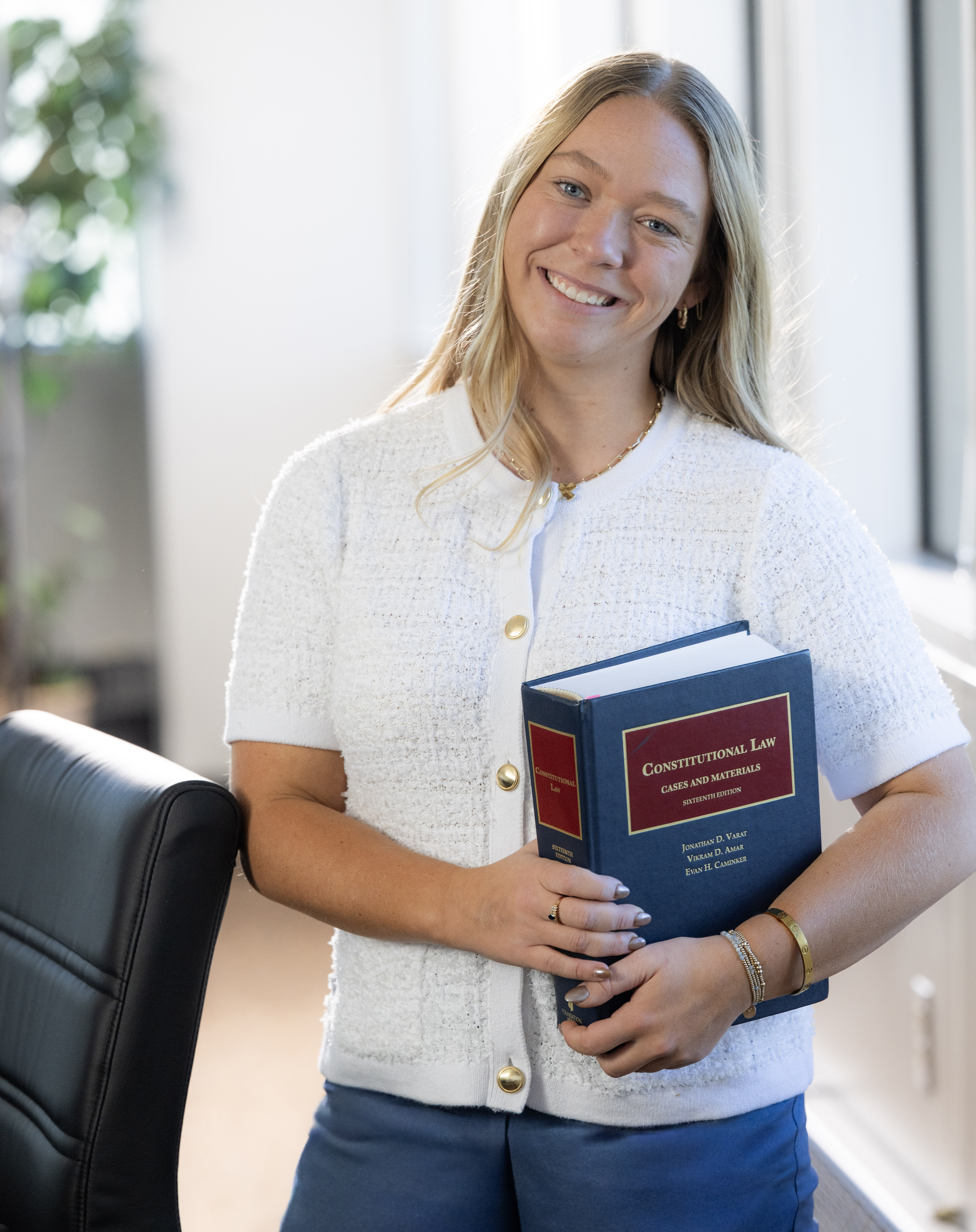 Portrait of a smiling Chase Law student holding a constitutional law book